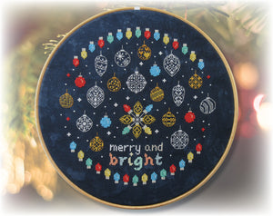 Baubles and Fairy Lights cross stitch pattern. A border of brightly coloured fairy lights, with mainly blackwork baubles and the words 'merry and bright' in cross stitch.